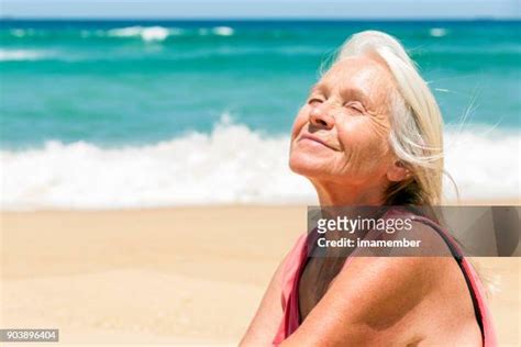 mature on the beach|Mature woman sunbathing beach Stock Photos and Images.